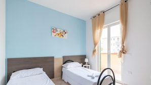 A hotel room with two single beds, a window with curtains, a wall with a Mickey Mouse painting, and a view of the outside. - Beachside Villa in Paestum (Capaccio-Paestum)