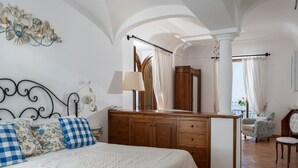 A bedroom with a bed, wooden dresser, and a chair.