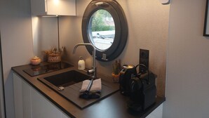 Een kleine badkamer met een wastafel, spiegel en een klein raam.