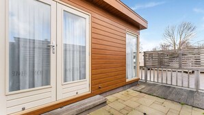 Un bâtiment moderne doté de grandes fenêtres et d’une façade en bois.