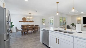A modern kitchen with white cabinetry, stainless steel appliances, and pendant lighting. - POSH LIVING in Fort Walton Beach (Fort Walton Beach)