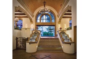 Stunning entrance hall with a grand staircase, vaulted ceiling, and elegant design.