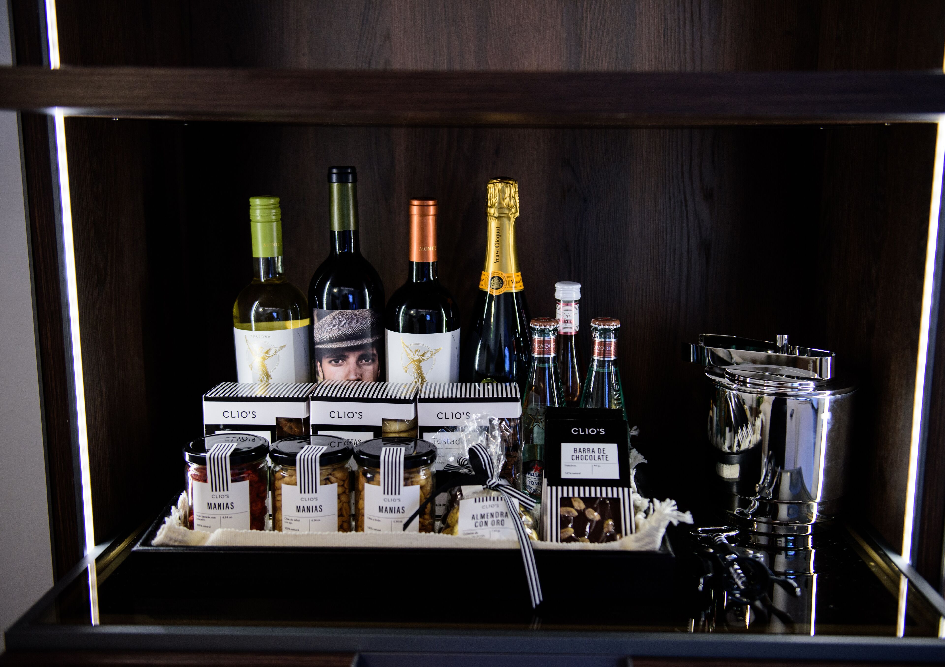 A display of wine bottles and chocolates in a wooden cabinet.