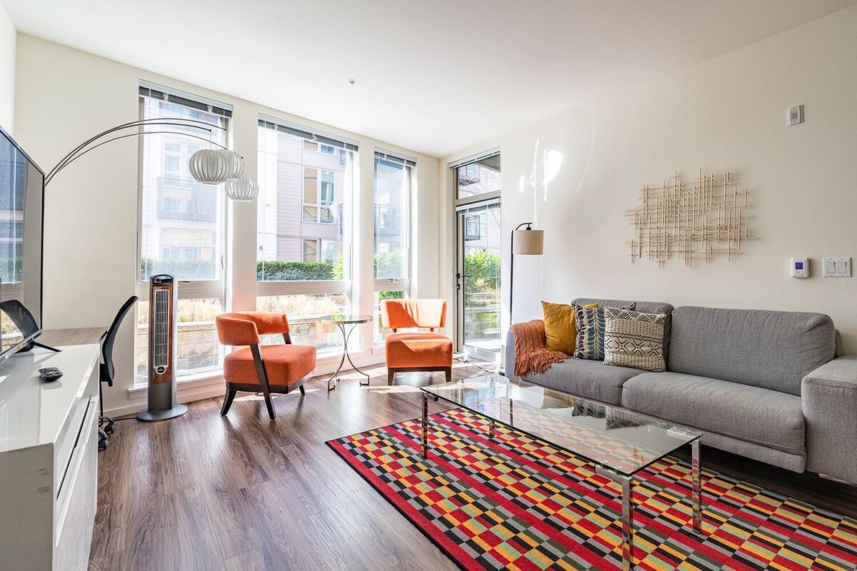 A modern living room with a sofa, two armchairs, a coffee table, and a floor lamp.