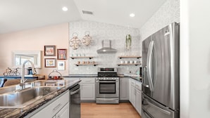 A modern kitchen with stainless steel appliances, wooden cabinets, and a patterned backsplash. - ✨Amazing Views✨Backyard Trails 🏜️Close to National Park, Shops, Restaurants ☕️ (Joshua Tree)