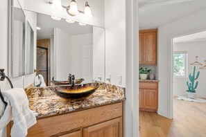 A modern bathroom with a large mirror, a vessel sink, wooden cabinets, and a potted plant. - ✨Amazing Views✨Backyard Trails 🏜️Close to National Park, Shops, Restaurants ☕️ (Joshua Tree)