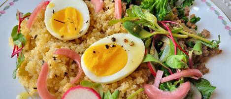 Un plato de comida con quinoa, huevos y verduras.