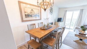 A dining area with a wooden table and chairs, a chandelier, and a framed picture on the wall. - Mountaintop condo with indoor and outdoor pools (Gatlinburg)