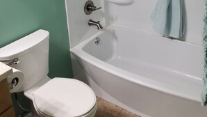 Kylpyhuone, jossa on wc, kylpyamme ja suihku.