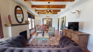 A living room with a fireplace, a television, and a large sofa.