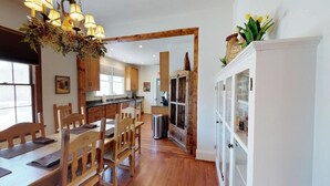 A kitchen with wooden cabinets, a dining table with chairs, and a chandelier.