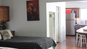 Ein Schlafzimmer mit Bett, Nachttisch und einem Gemälde an der Wand.
