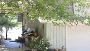 Eine Garage mit einer Werkbank, einem kleinen Baum und einem Geräteschuppen.