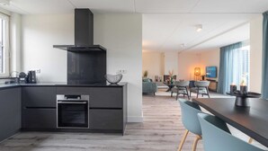 Eine moderne Küche mit eingebautem Backofen und einer großen schwarzen Dunstabzugshaube.