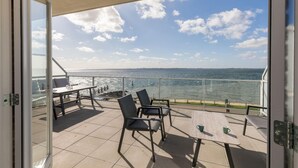 A balcony with a table and chairs, overlooking a body of water. - Apartment on Tholen by Oosterschelde Estuary (Scherpenisse)