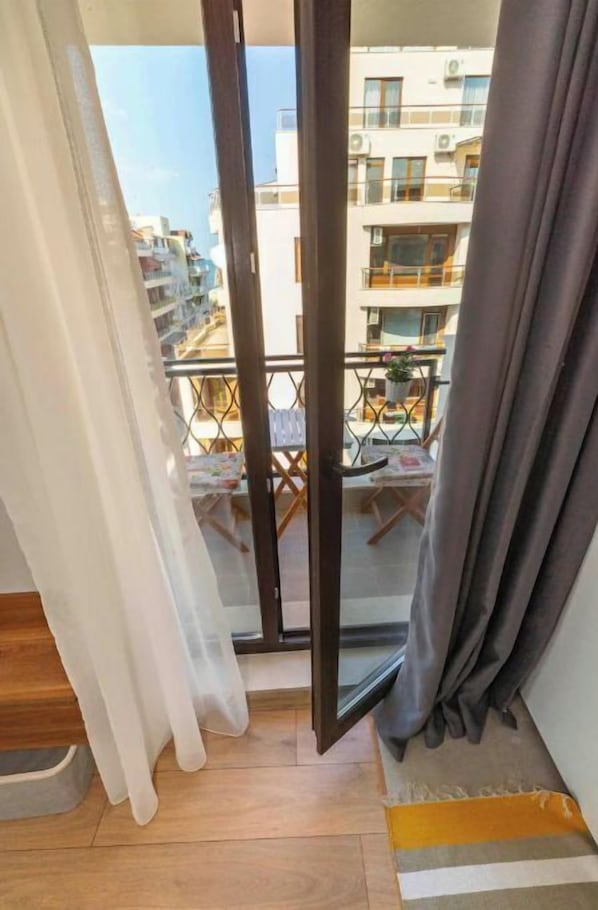 Enjoy the view from this balcony with a glass door leading to an outdoor space.