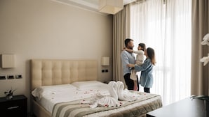 Una habitación de hotel con una cama grande, una mesita de noche y un escritorio.