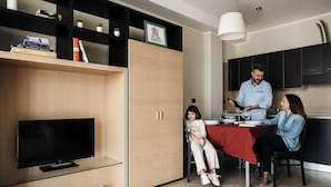 Una sala de estar moderna con televisor, un mueble de madera y una estantería.