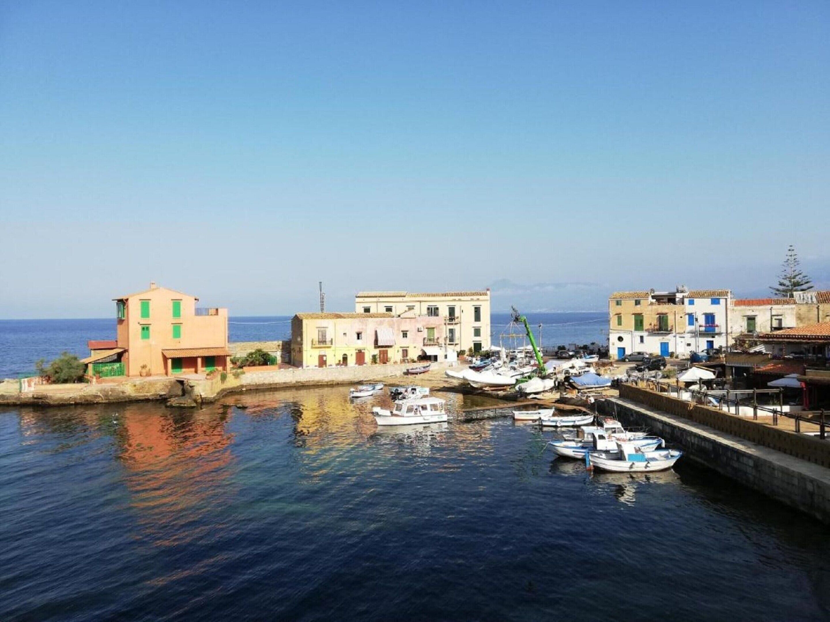 Une ville côtière dotée d’un port de plaisance, de bâtiments avec des balcons et offrant une vue dégagée sur la mer.