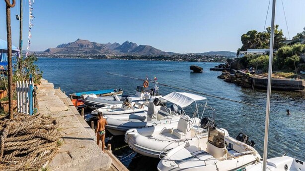 A marina with several boats docked, a clear sky, and a mountainous landscape in the background. - Villa in Sicily With Sea Access (Santa Flavia)