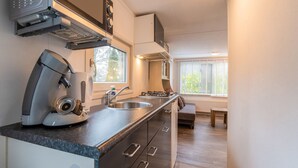 A compact kitchen with a built-in oven, a coffee machine, and a sink. - Beautiful Holiday Chalet in Emst With a Private Garden (Emst)