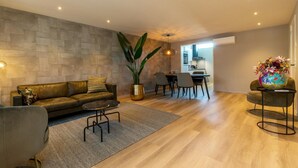 Un salon moderne comprenant un canapé, une table basse et un coin repas avec des chaises et une table.