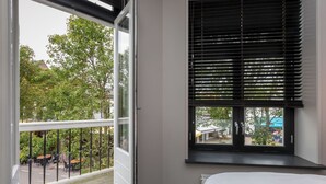 Una habitació amb un finestral gran, un llit i vista a l'exterior.