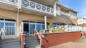 A two-story building with a brick facade, large windows, and a white balcony railing. - Spacious Flat With Views of the Harbour (Ouddorp)
