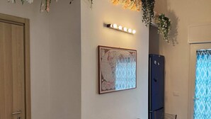 Un comedor con una mesa de madera, sillas, un cuenco decorativo, un mapa en la pared y un refrigerador.