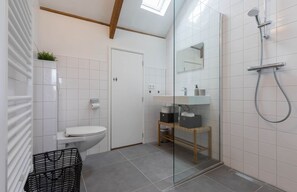 A modern bathroom with a toilet, sink, and shower. - Cozy Apartment in Villa Koudekerke (Koudekerke)