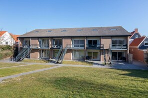A two-story building with a flat roof, large windows, and a central staircase. - Apartment in Zoutelande by the Beach (Zoutelande)