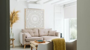 Ein Wohnzimmer mit einem beigefarbenen Sofa, einem Holztisch und einem Wanddekor.