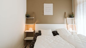 A bedroom with a bed, white headboard, and a sign on the wall. - Lovely Holiday Home 10 Minutes by Bike (Ouddorp)