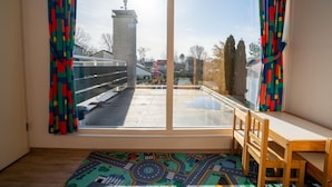 A room with a large window, a wooden desk, a chair, and a colorful rug. - Holiday Home in the Middle of the Green North Sea Park Near the Beach Entrance (Ouddorp)