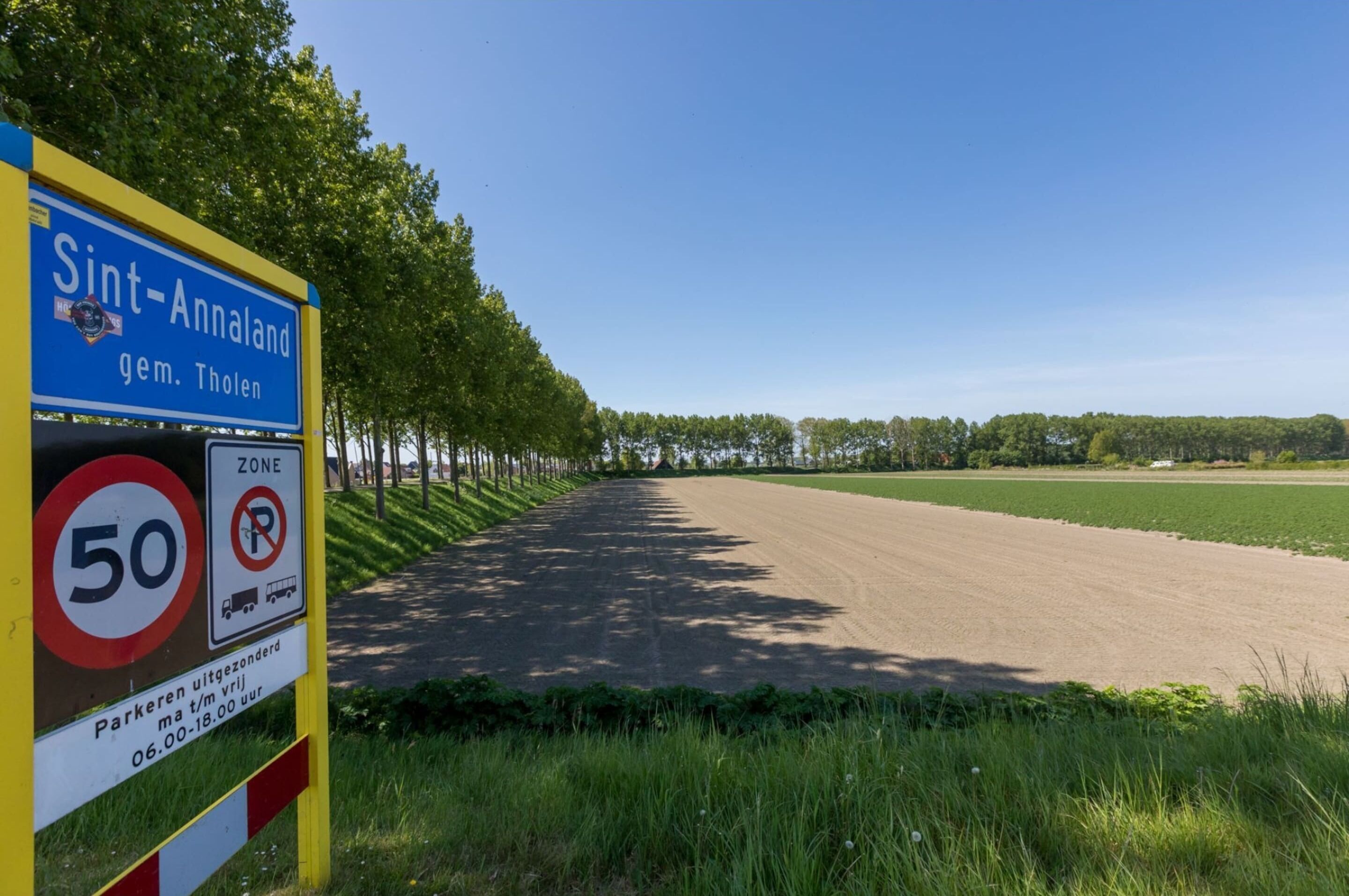 A sign indicating Sint-Annaland gem. Tholen with a speed limit of 50 km/h and parking restrictions.