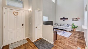 A living room with a sofa, TV, and decorative wall art. - Gated Dual Master Suites with Office and Dog Park (Las Vegas)