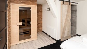 A modern bedroom with a wooden wardrobe, a sliding door, and a black rug. - Studio in Domburg Near Beach and Nature Reserve (Renesse)