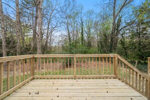 A wooden deck with railings, surrounded by trees and greenery. - The Sanctuary Downtown >5mi to Downtown & Union Park (Raleigh)