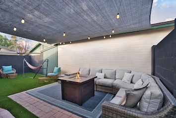 String lights overhead with ample seating to sit around the fire pit and relax!
