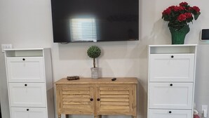 A room with a wooden dresser, a television mounted on the wall, and a small potted plant on the floor. - 35-45 Min to Lackland AFB! Gorgeous Ranch-Style Home!  (Floresville)