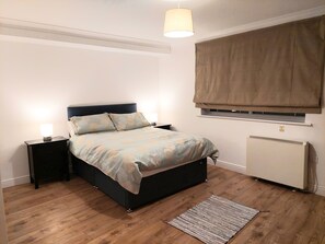 Cozy retreat with a single bed, bedside table, and lamp.