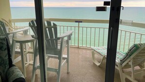 A balcony with white chairs and a table, overlooking a calm sea. - Breathtaking Views Oceanfront 2 Bed 2 Bath Condo Water's Edge Resort Garden City (Murrells Inlet)