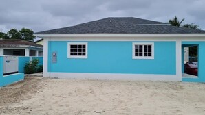 A single-story building with a flat roof, two windows, and a door. - Yamabeach Stays (Nassau)