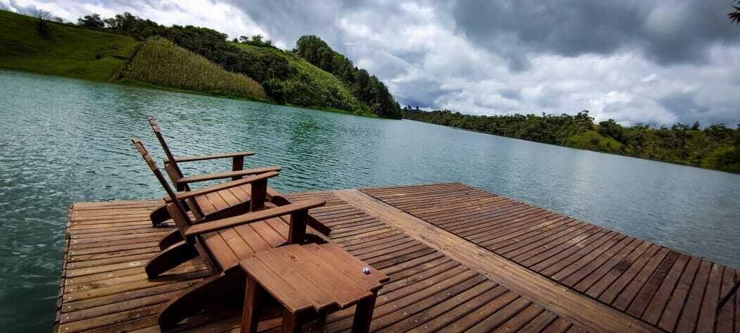 Eine hölzerne Mole mit einer Bank und einem Tisch an einem ruhigen See, umgeben von üppigem Grün.
