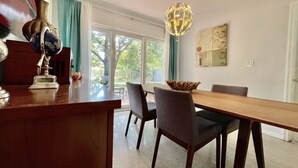 A dining area with a wooden table and chairs, a globe on the counter, and a hanging light fixture.