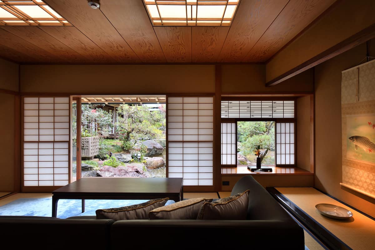 A traditional Japanese room with tatami flooring, a low table, and a sofa.
