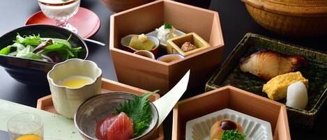 A variety of traditional Japanese dishes arranged on a table, including sushi, rice, and pickled vegetables.