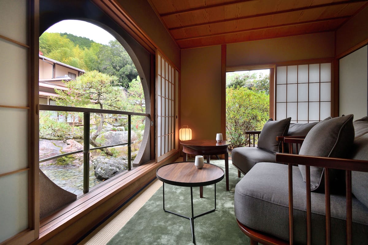 A traditional Japanese room with tatami flooring, a low wooden table, and a sofa.