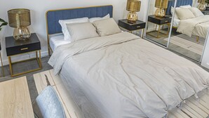 Ein ordentlich eingerichtetes Schlafzimmer mit einem Bett, Nachttischen und einem Spiegel.