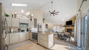 A spacious kitchen with a central island, built-in oven, microwave, and a dining area with a table and chairs. - Lakefront House w/ Private Dock in a Protected Cove -Swim, Kayak, Fish!  MM20 (Osage Beach)